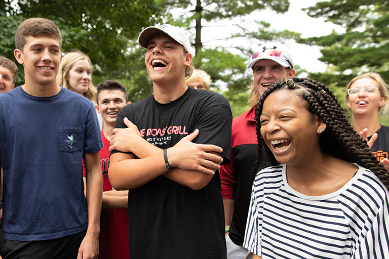 Students on campus laughing together.
